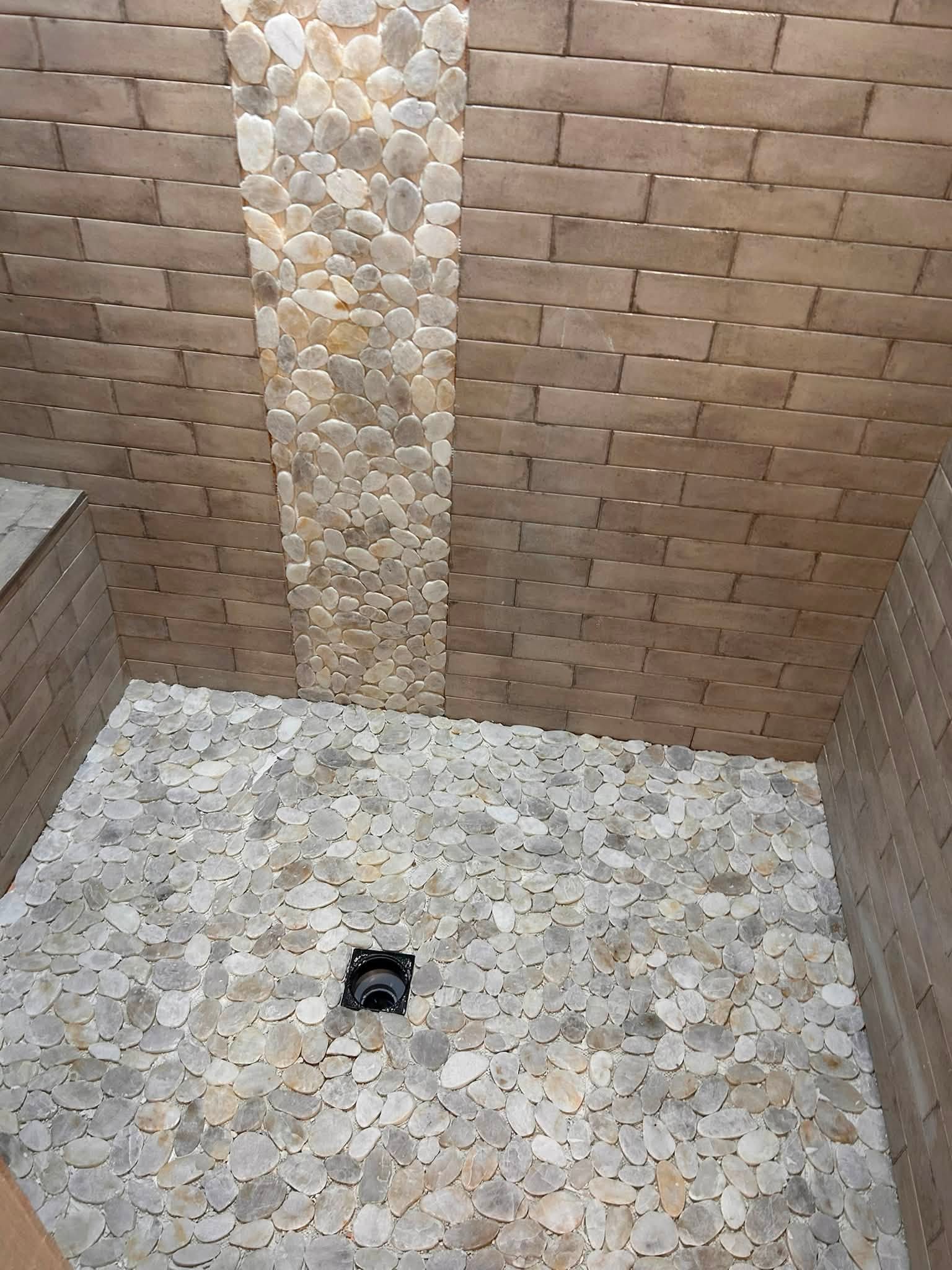 Stone and pebble tile detail in a custom shower space