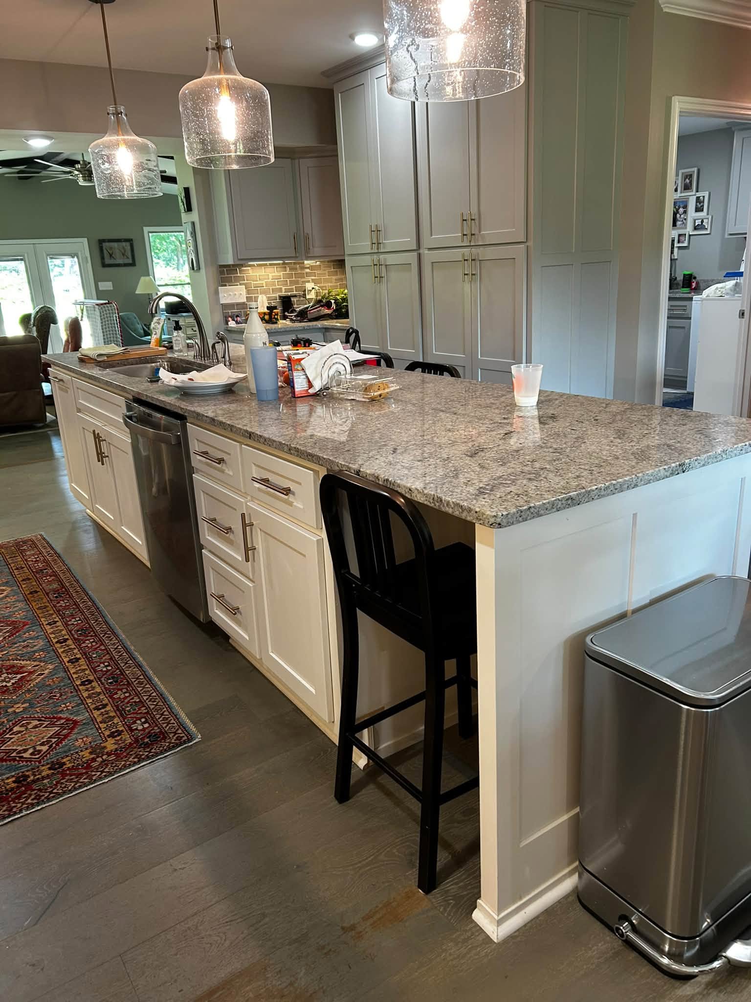 Kitchen with detailed cabinetry, stone countertop and warm pendant lights