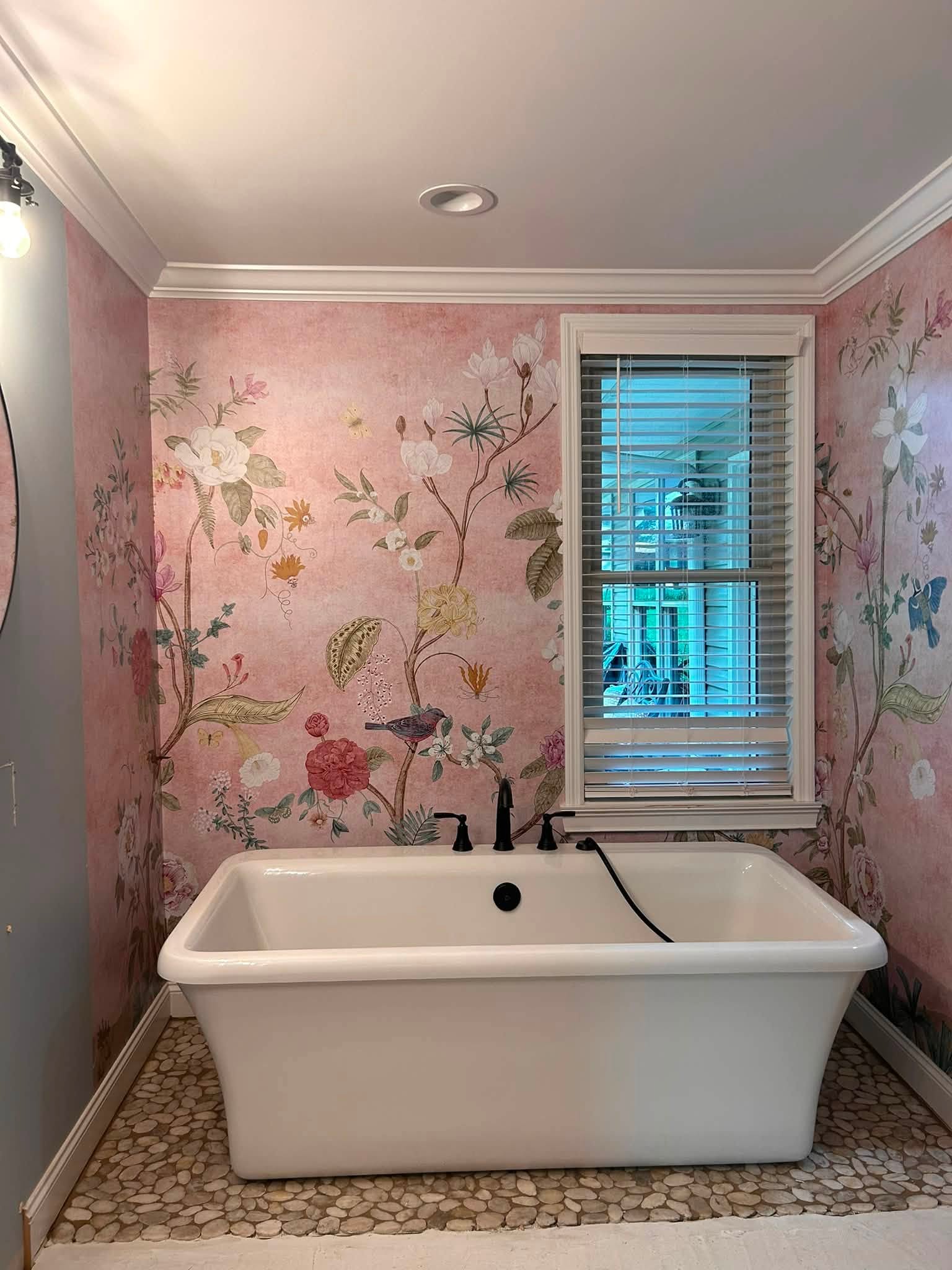 Bathroom retreat with a freestanding tub and softly patterned pink walls